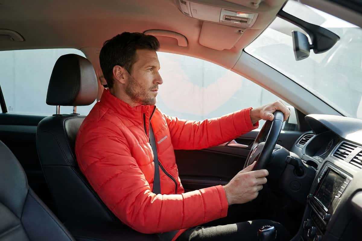 Мужчина за рулем в мужской куртке для водителей