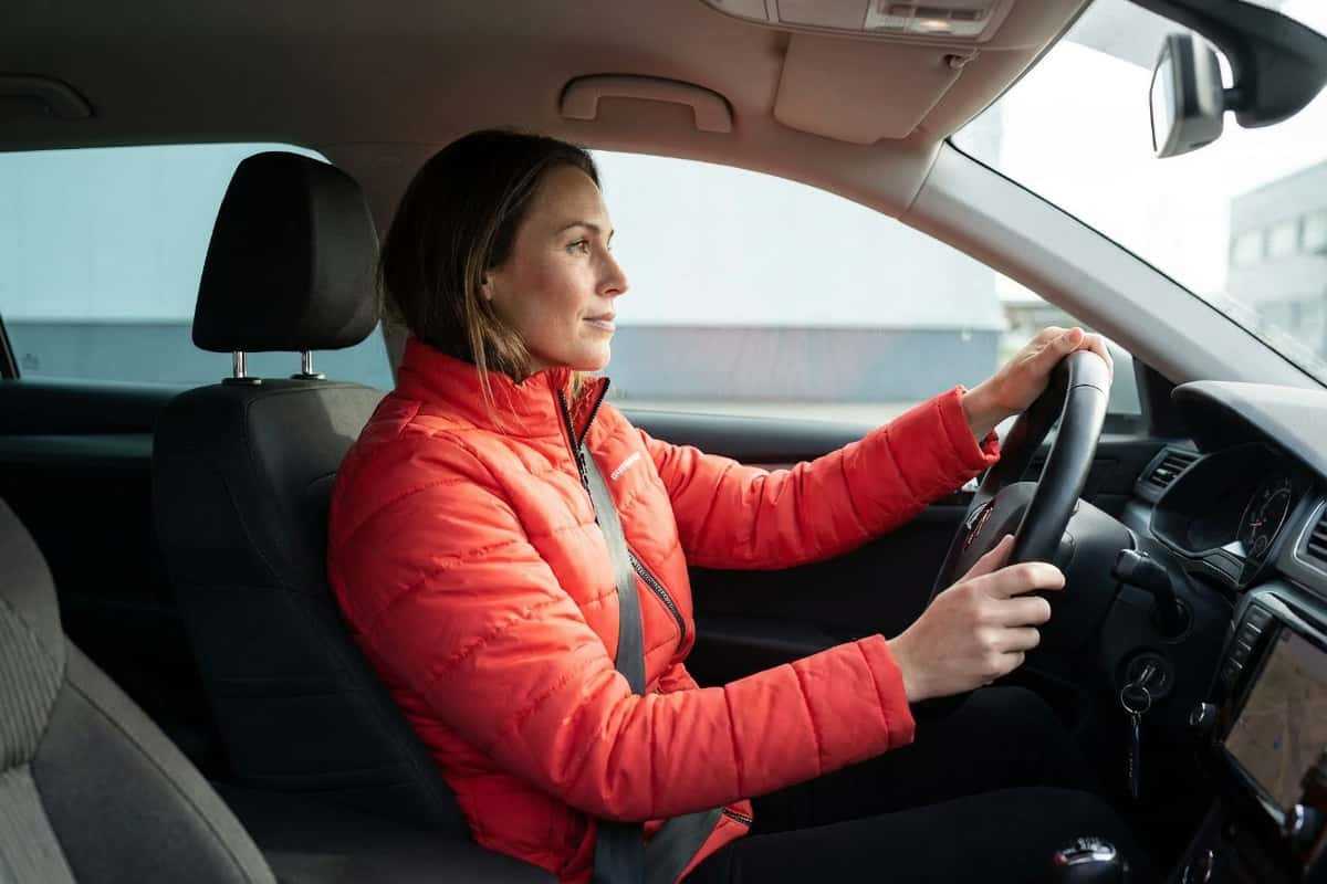Женщина за рулем в женской куртке для водителей